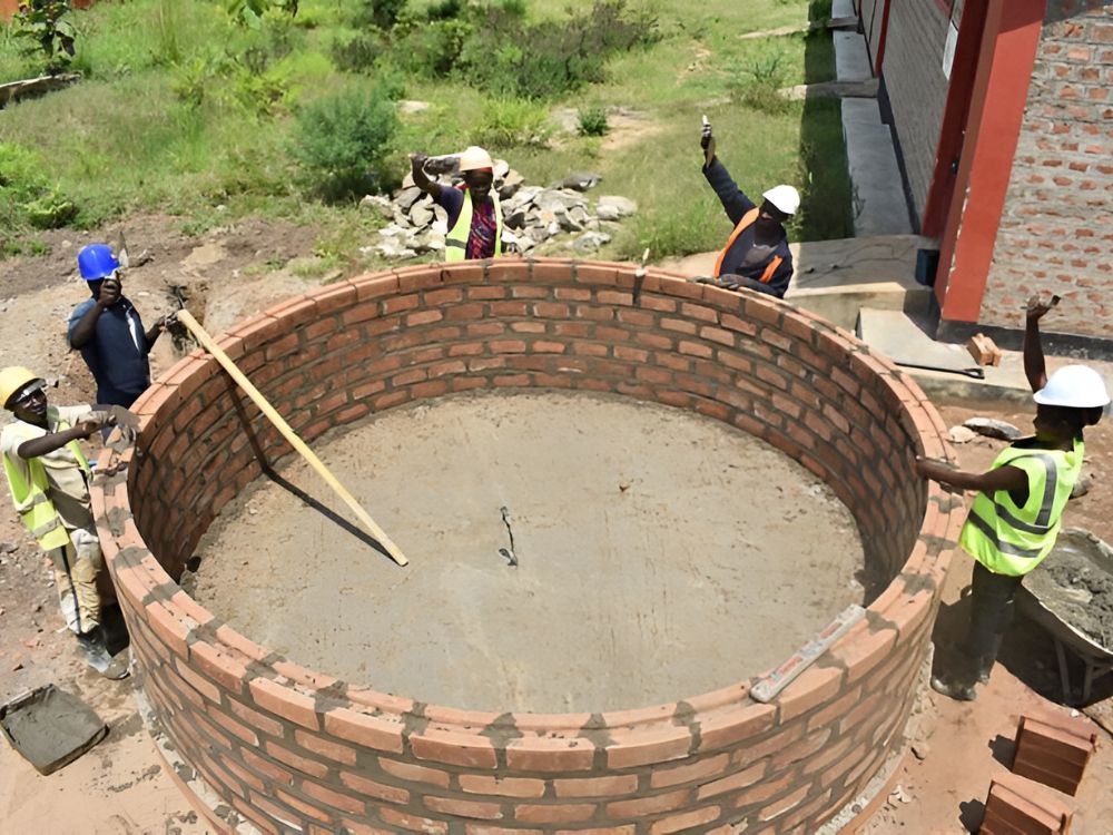 Concrete water tank under construction in Kenya, showing durable masonry for large-scale storage.