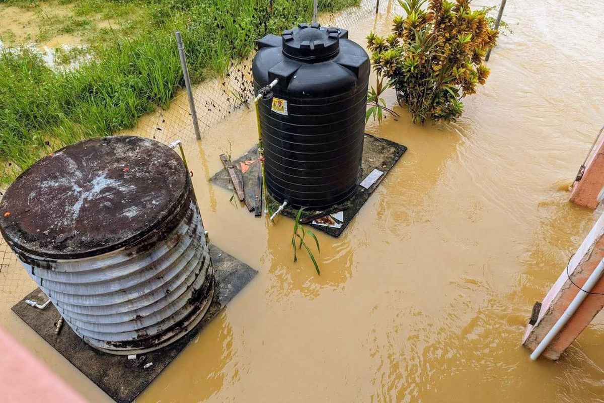 Two water tanks partially submerged in floodwaters, emphasizing the need for emergency water tank cleaning after a flood.