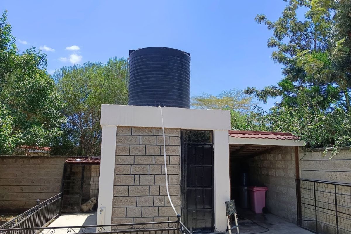 Black water storage tank on a concrete platform, emphasizing the need for water quality testing to ensure safety